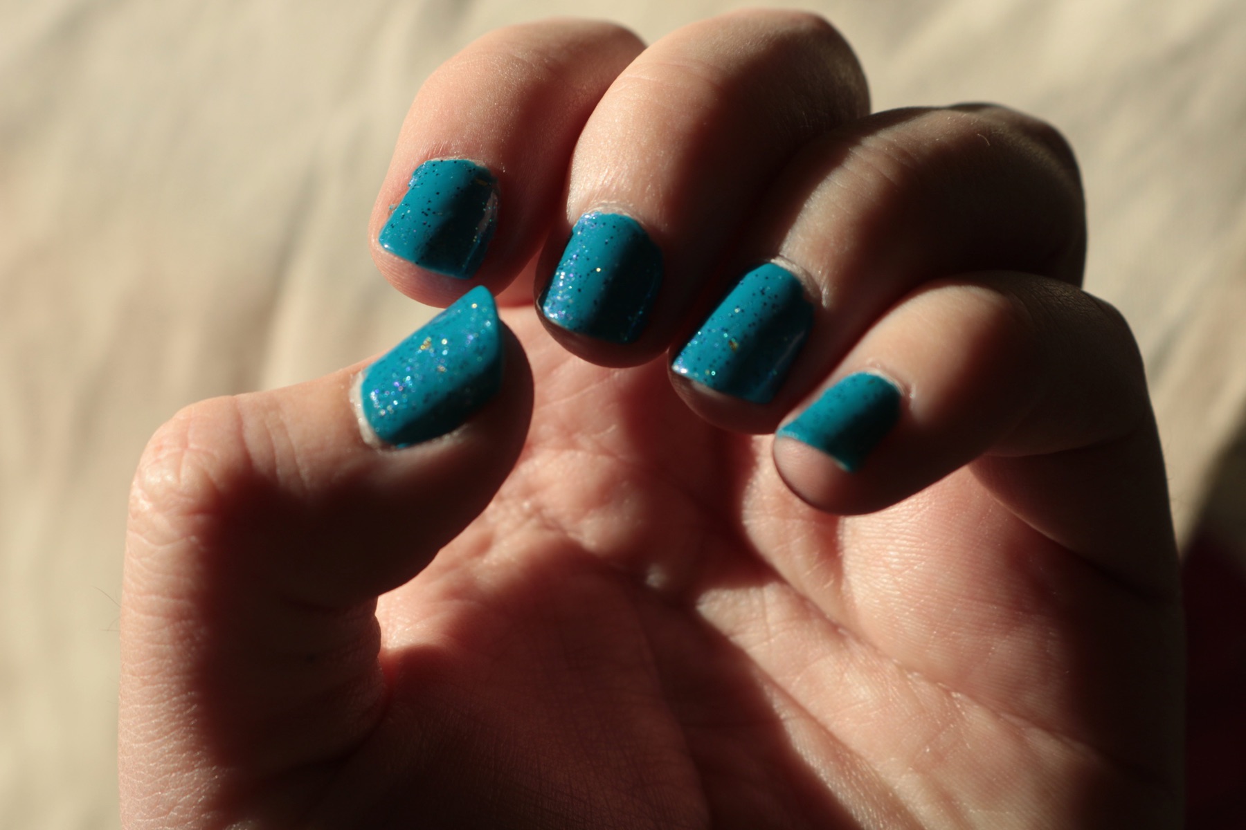 L.A. Colors “Aquatic” as a greenish-blue solid-color ground for Defy & Inspire “Challenge Your Limits” glitter polish.